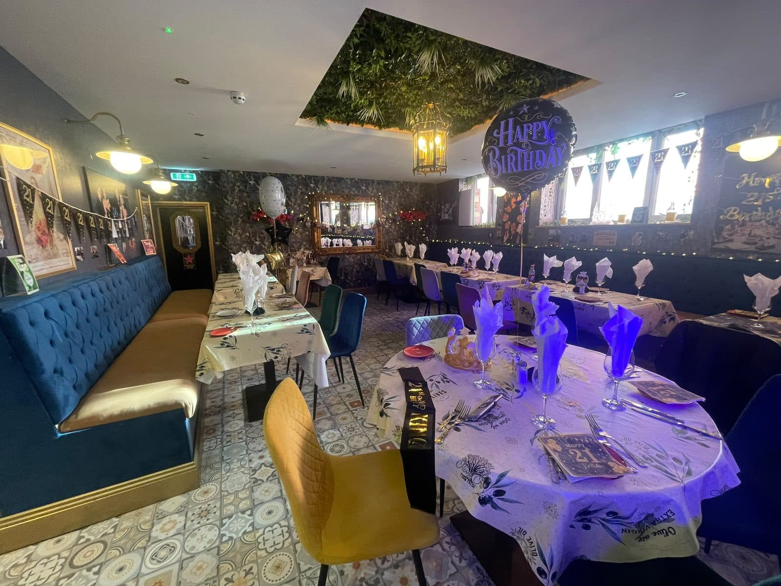 The Soprano Suite decorated for a 21st birthday — balloons, bunting and tables laid under the green living-wall ceiling