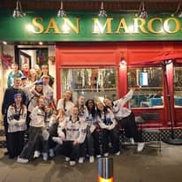 A group of guests outside the San Marcos shopfront at night