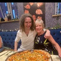Two guests sharing a pizza at their table